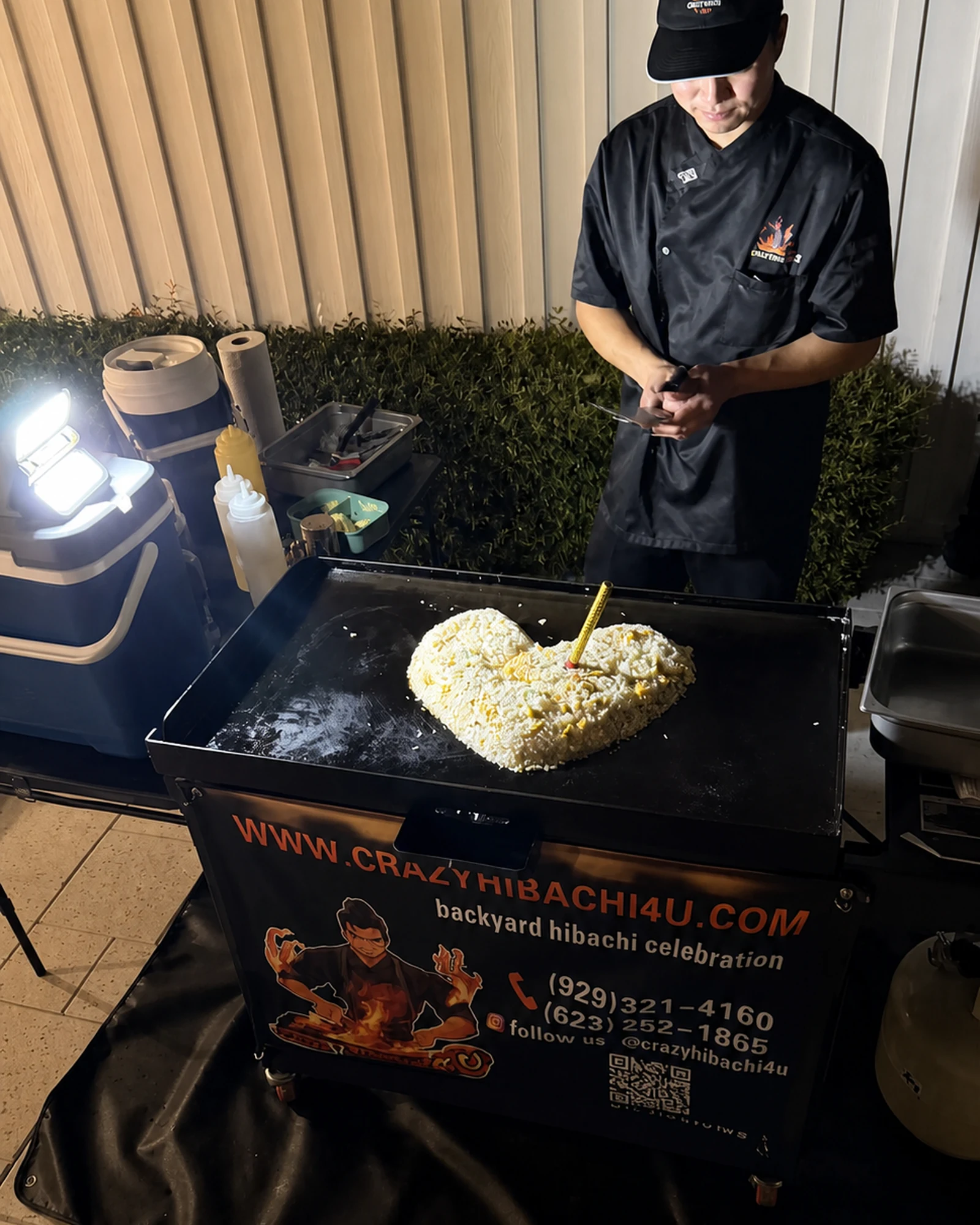 Hibachi chef shaping fried rice into a heart on a flat-top grill