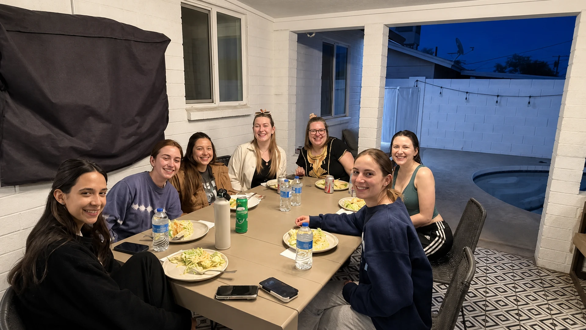 Women smiling around an outdoor table during a private hibachi dinner