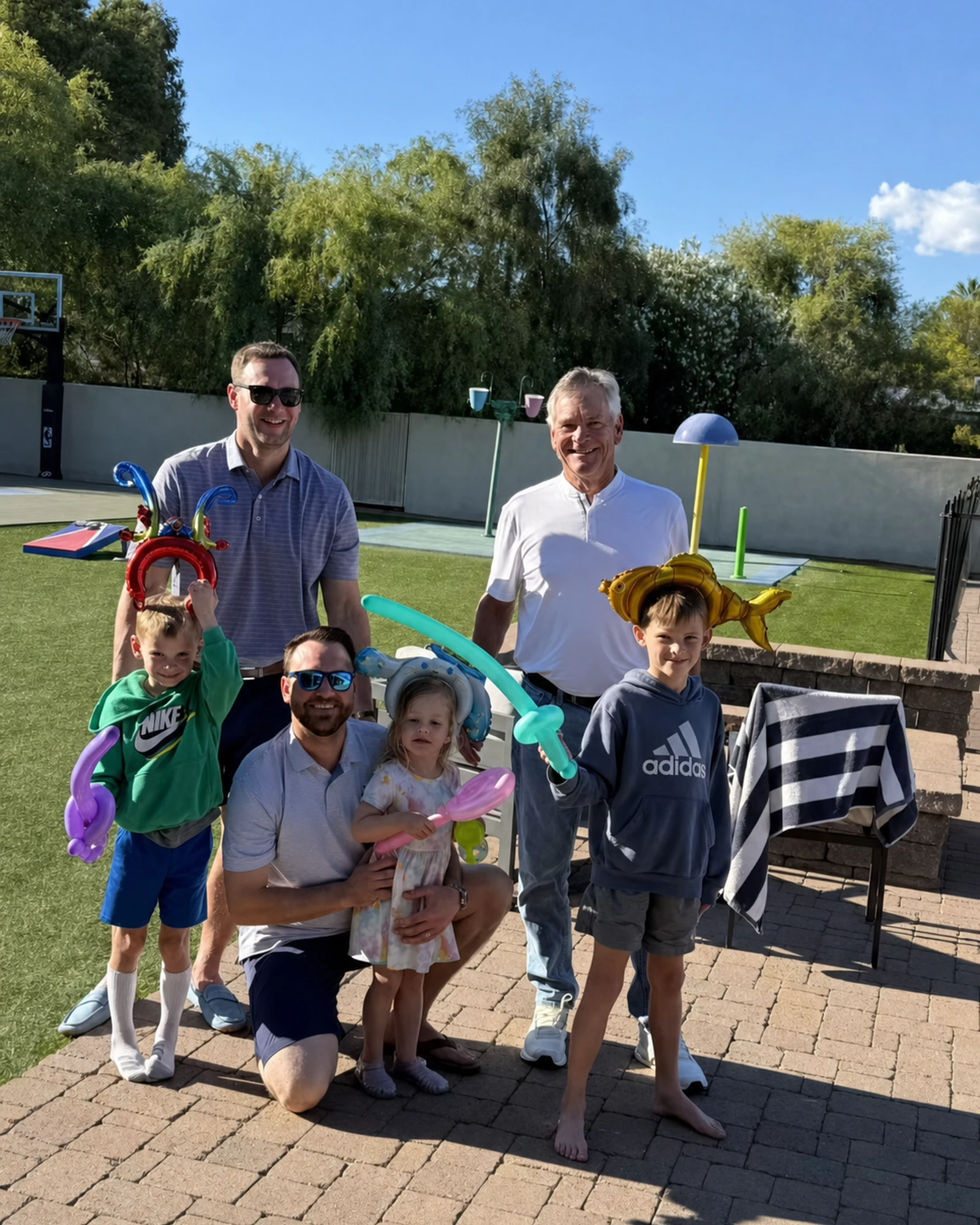 Children and adults enjoying a sunny backyard activity during a hibachi party