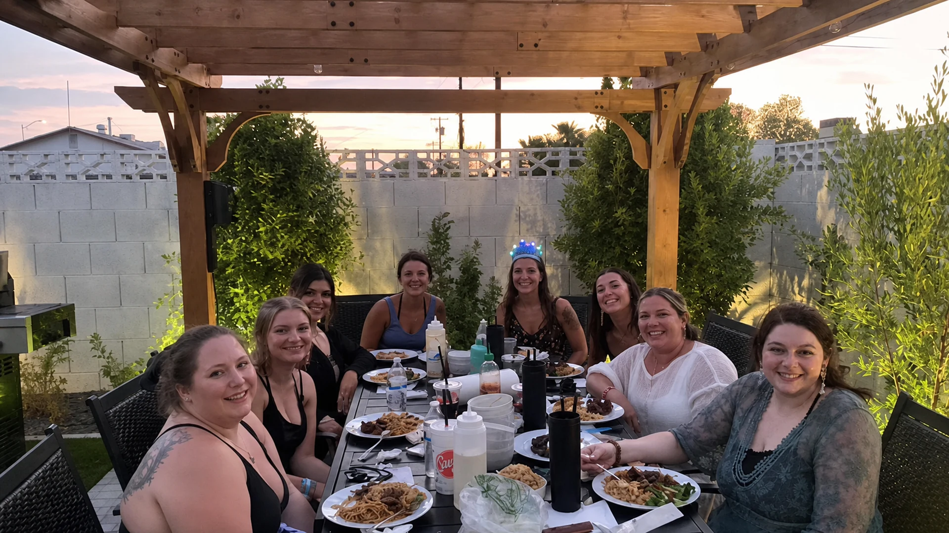 Friends enjoying a private hibachi meal beneath a backyard pergola