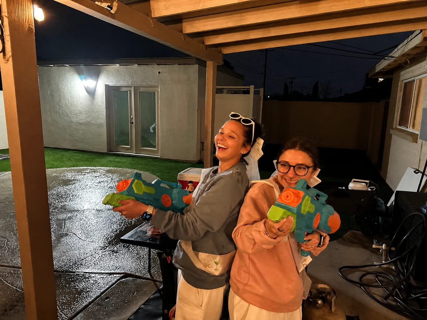 Guests playing a water gun game during a rainy hibachi party