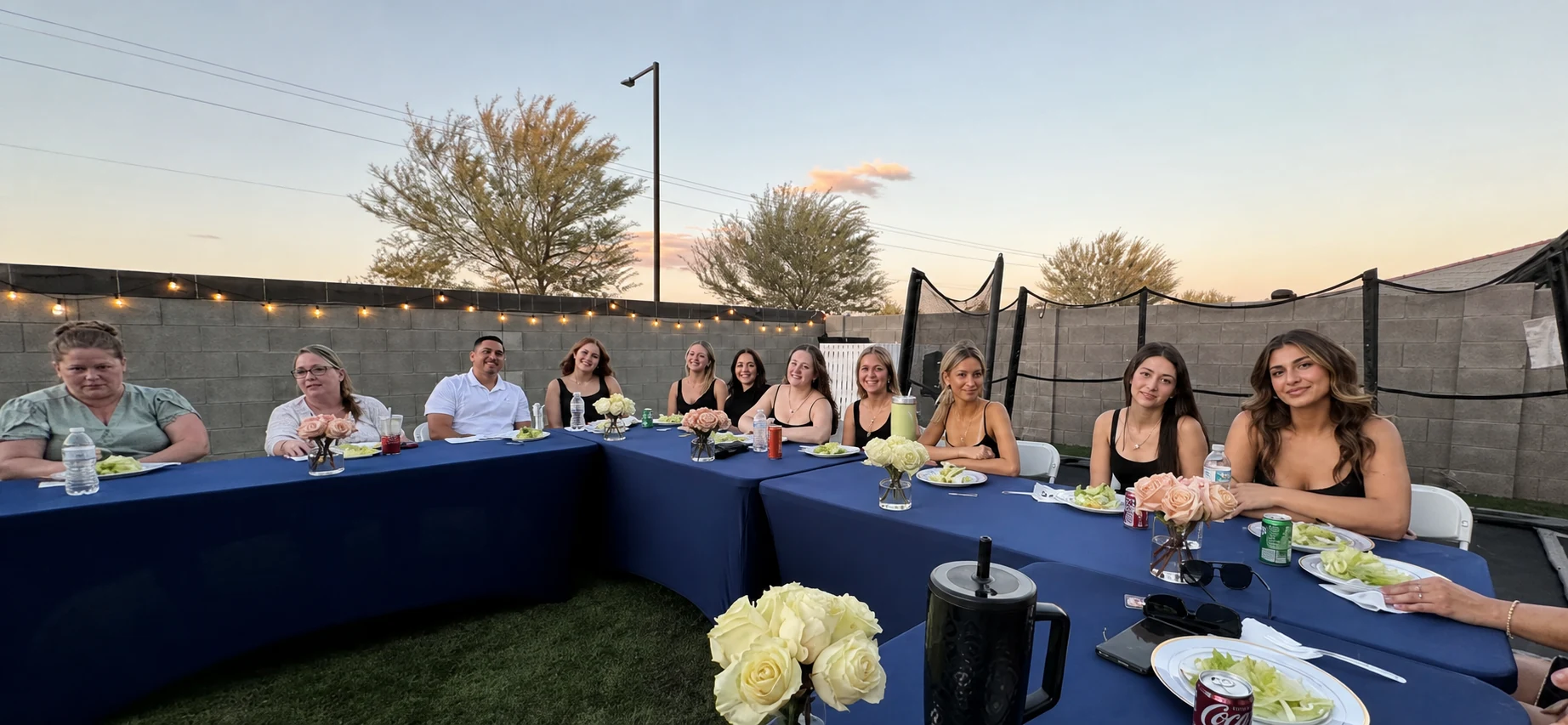 Guests seated at a blue table for an outdoor sunset hibachi dinner