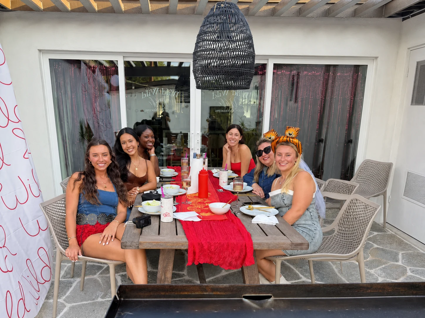 Women gathered around a red table for a private hibachi dinner