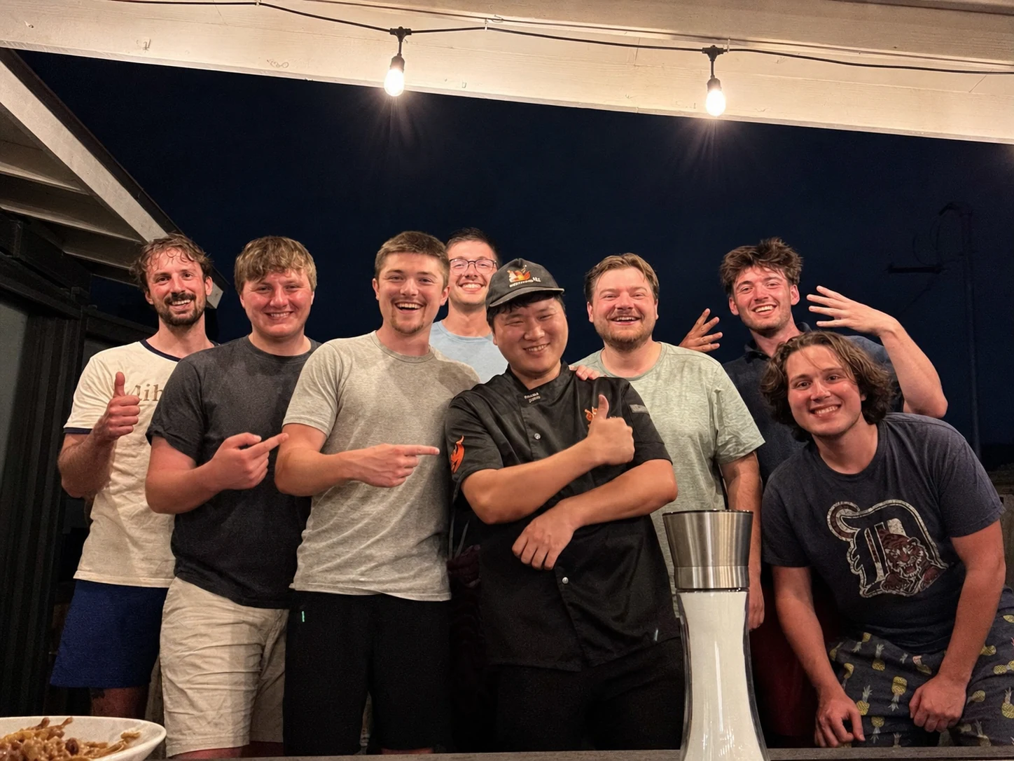 Hibachi chef posing with a group of men after dinner
