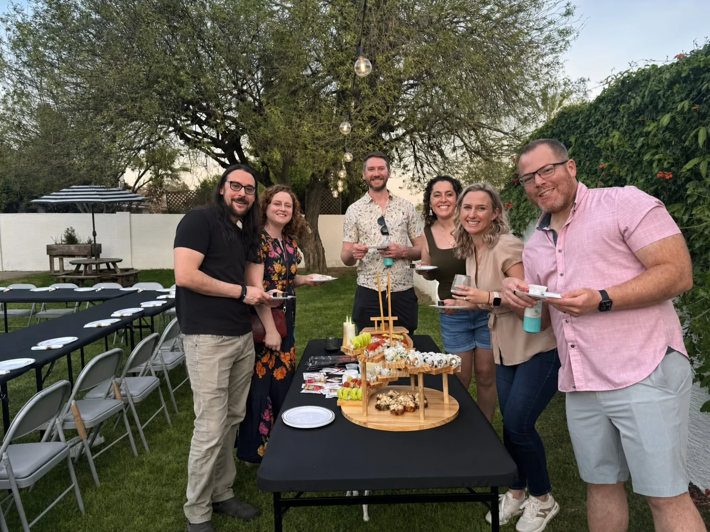 Guests posing behind a sushi display at a private hibachi event