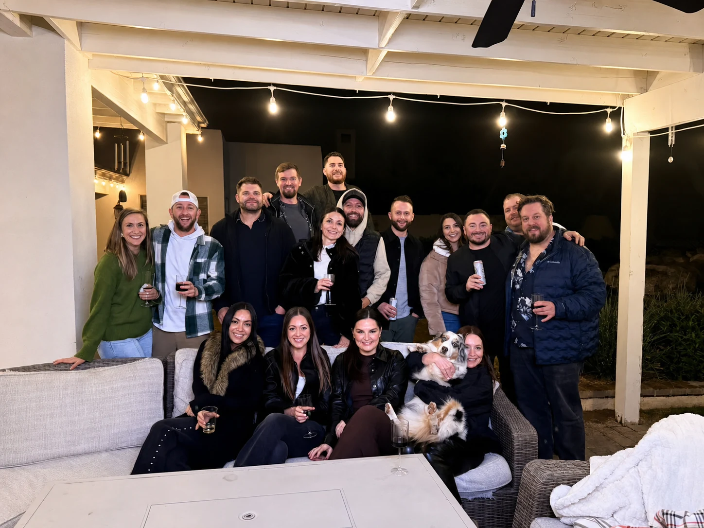 Friends and a dog posing together after a nighttime patio hibachi dinner