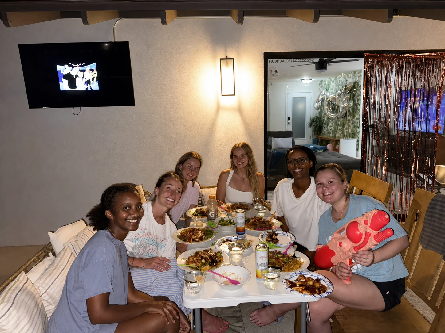 Women laughing during an indoor hibachi water gun activity