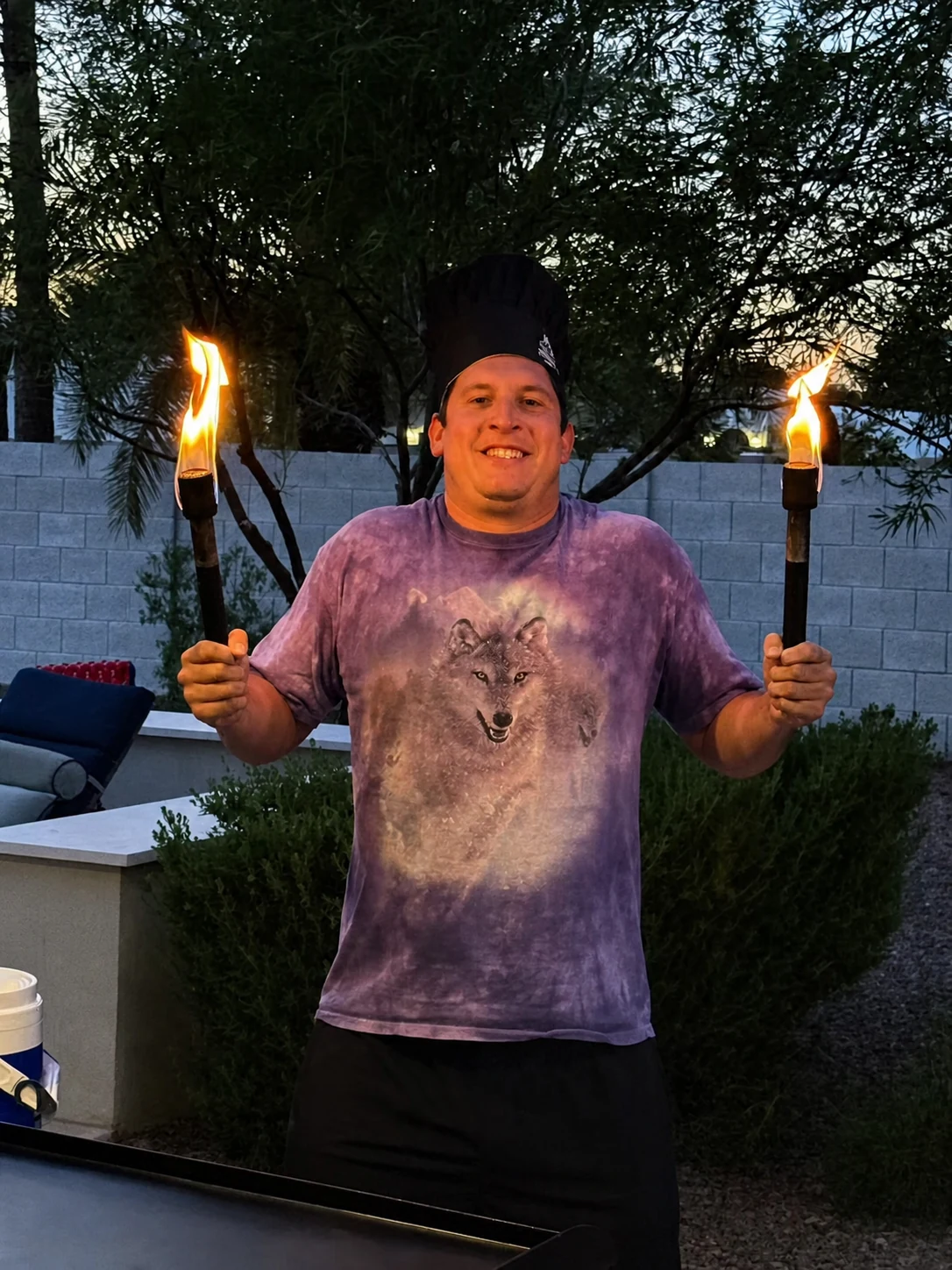 Guest holding two flaming torches during an outdoor hibachi celebration